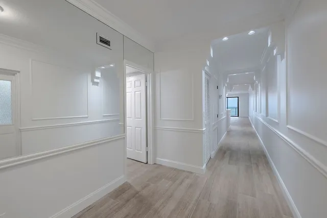 a view of a hallway with wooden floor