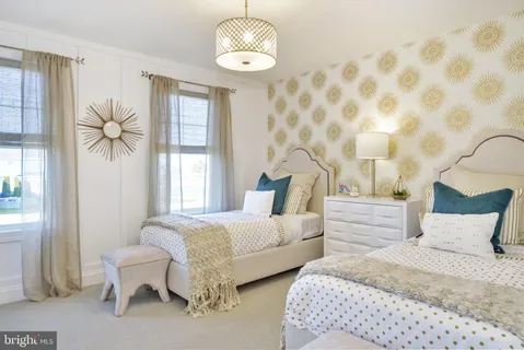 a spacious bedroom with two beds and a chandelier