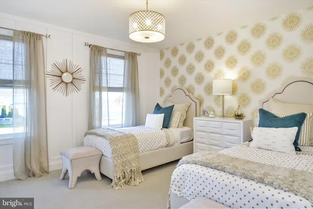 a spacious bedroom with two beds and a chandelier