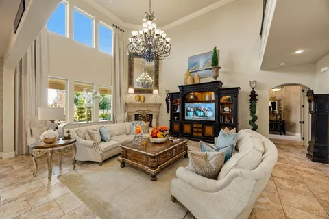 a living room with fireplace furniture and a chandelier