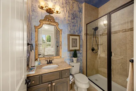 a bathroom with a sink a toilet mirror and shower