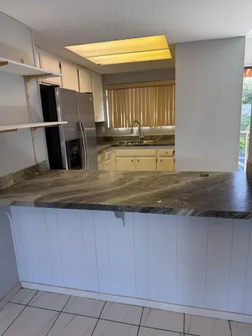 a kitchen with kitchen island a sink stainless steel appliances and a window