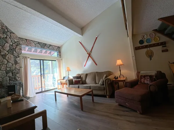 a living room with furniture and a flat screen tv with wooden floor