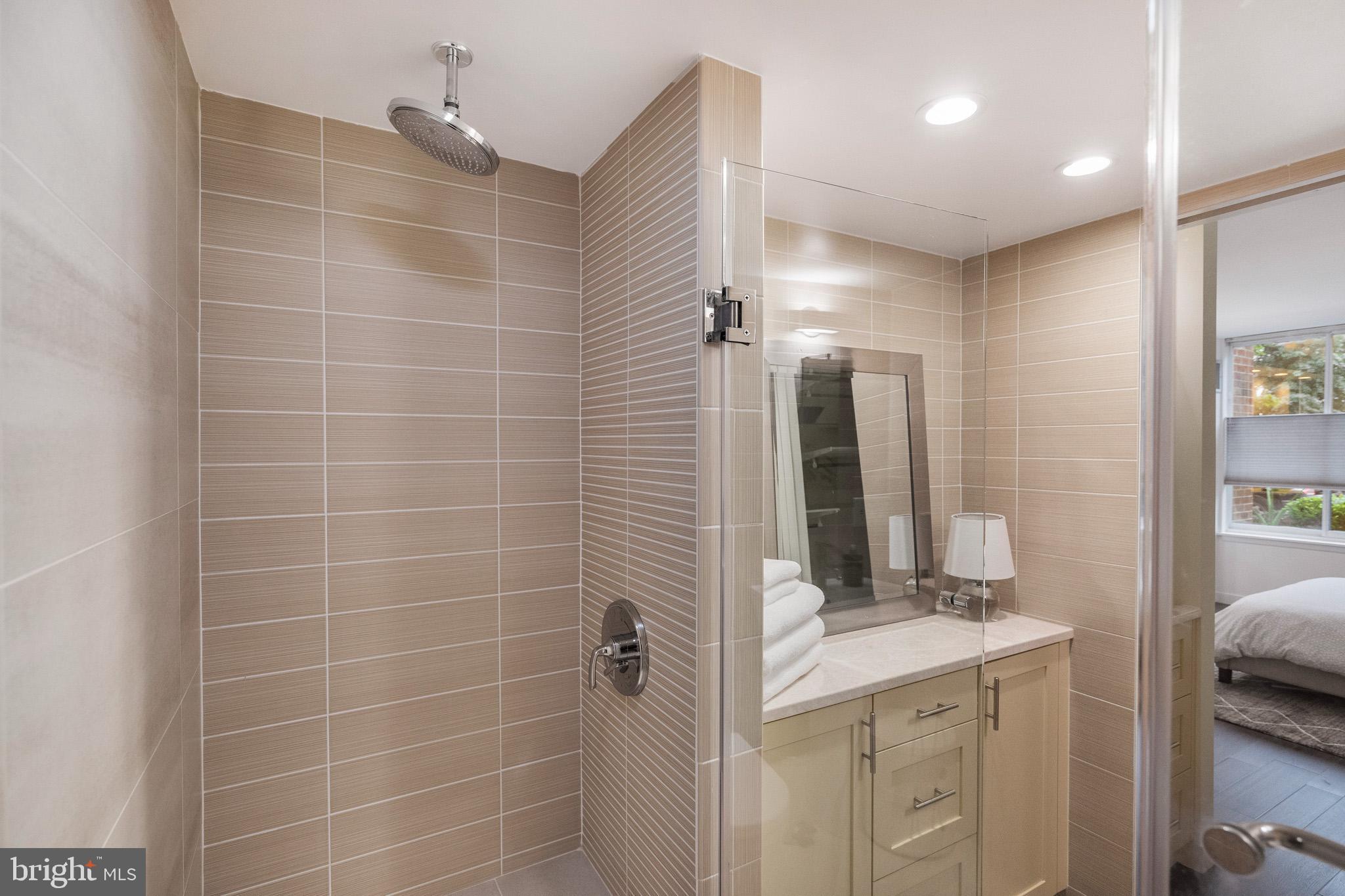 1301 20th Street Northwest, Unit 109 Washington, DC 20036 - Photo 22 of 33 a bathroom with a granite countertop sink and a mirror