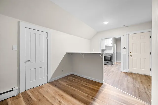 a view of empty room with wooden floor