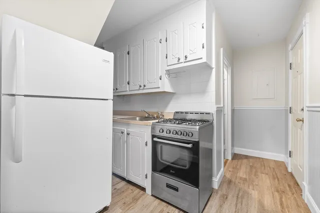 a kitchen with a stove top oven and refrigerator
