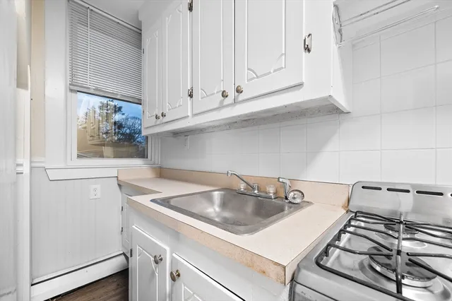 a kitchen with a sink cabinets and a stove top oven