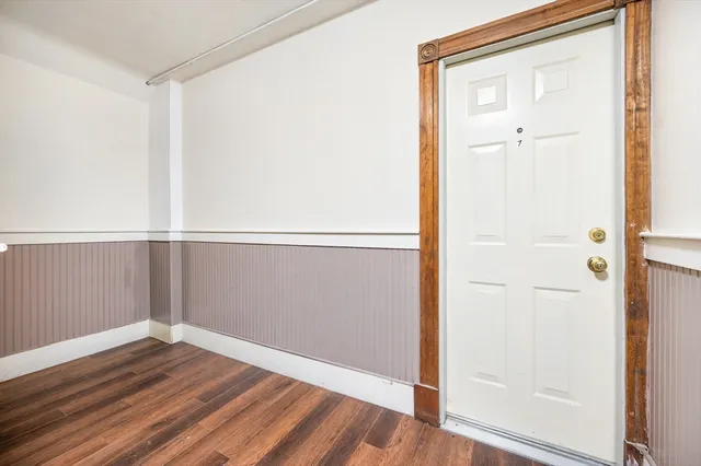 an empty room with wooden floor and mirror
