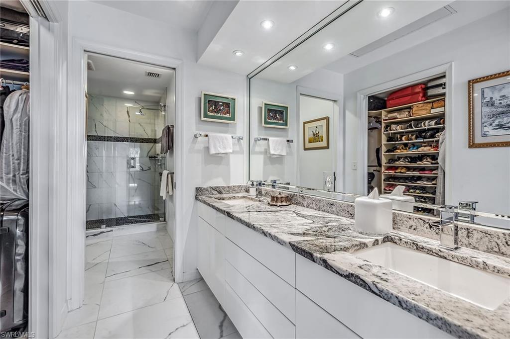 764 Eagle Creek Drive, Unit 301 Naples, FL 34113 - Photo 11 of 31 a bathroom with a granite countertop sink mirror and shower