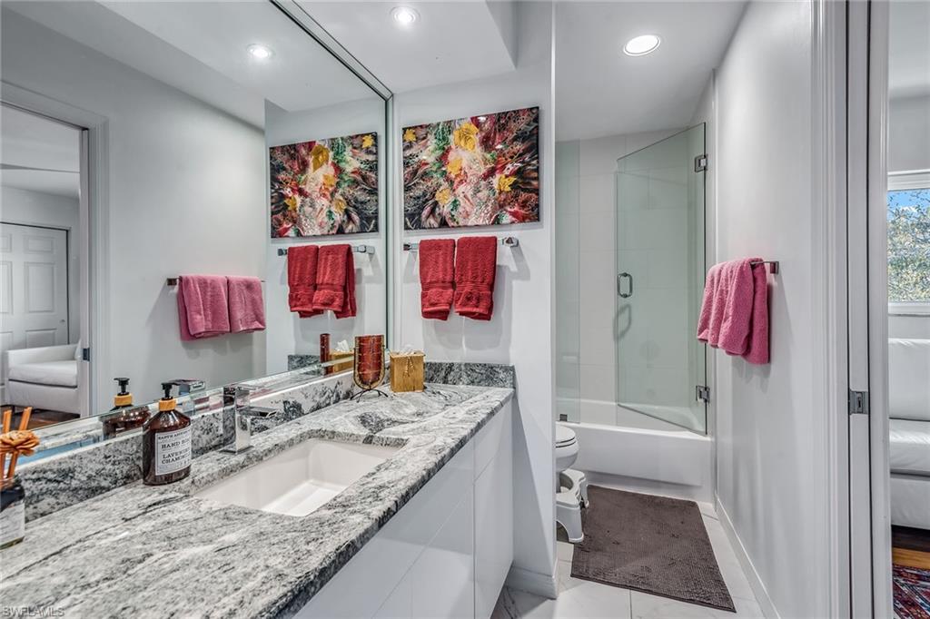 764 Eagle Creek Drive, Unit 301 Naples, FL 34113 - Photo 16 of 31 a bathroom with a granite countertop sink a mirror and shower