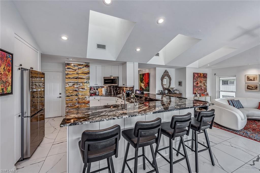 764 Eagle Creek Drive, Unit 301 Naples, FL 34113 - Photo 8 of 31 a large kitchen with a table and chairs