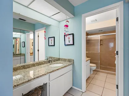 a bathroom with a granite countertop sink mirror vanity and toilet