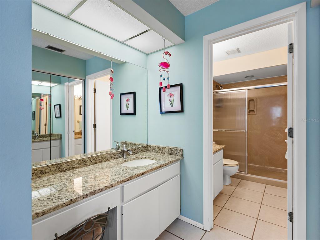 4415 Longmeadow, Unit 44 Sarasota, FL 34235 - Photo 19 of 42 a bathroom with a granite countertop sink mirror vanity and toilet
