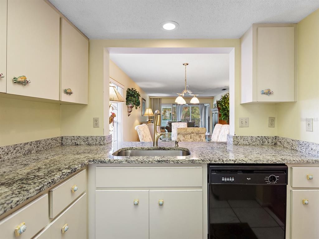 4415 Longmeadow, Unit 44 Sarasota, FL 34235 - Photo 9 of 42 a kitchen with granite countertop a sink stainless steel appliances and cabinets
