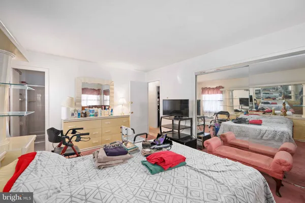 a bedroom with furniture a flat screen tv and a window