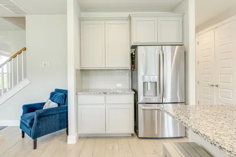 a kitchen with granite countertop white cabinets and window