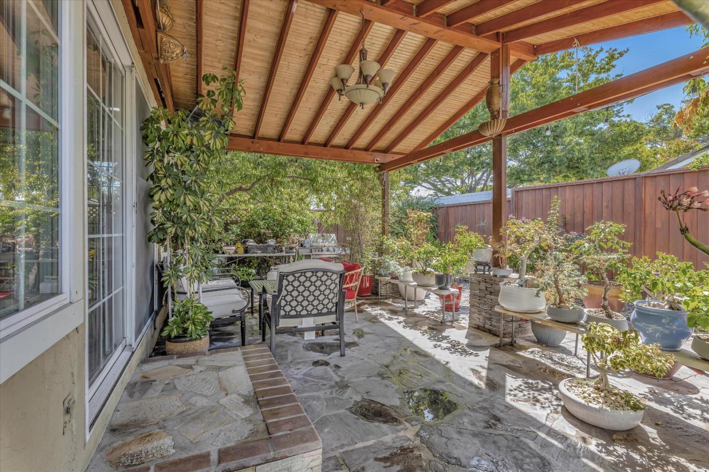 252 Sposito Circle San Jose, CA 95136 - Photo 16 of 50 a view of a patio with table and chairs potted plants and floor to ceiling window