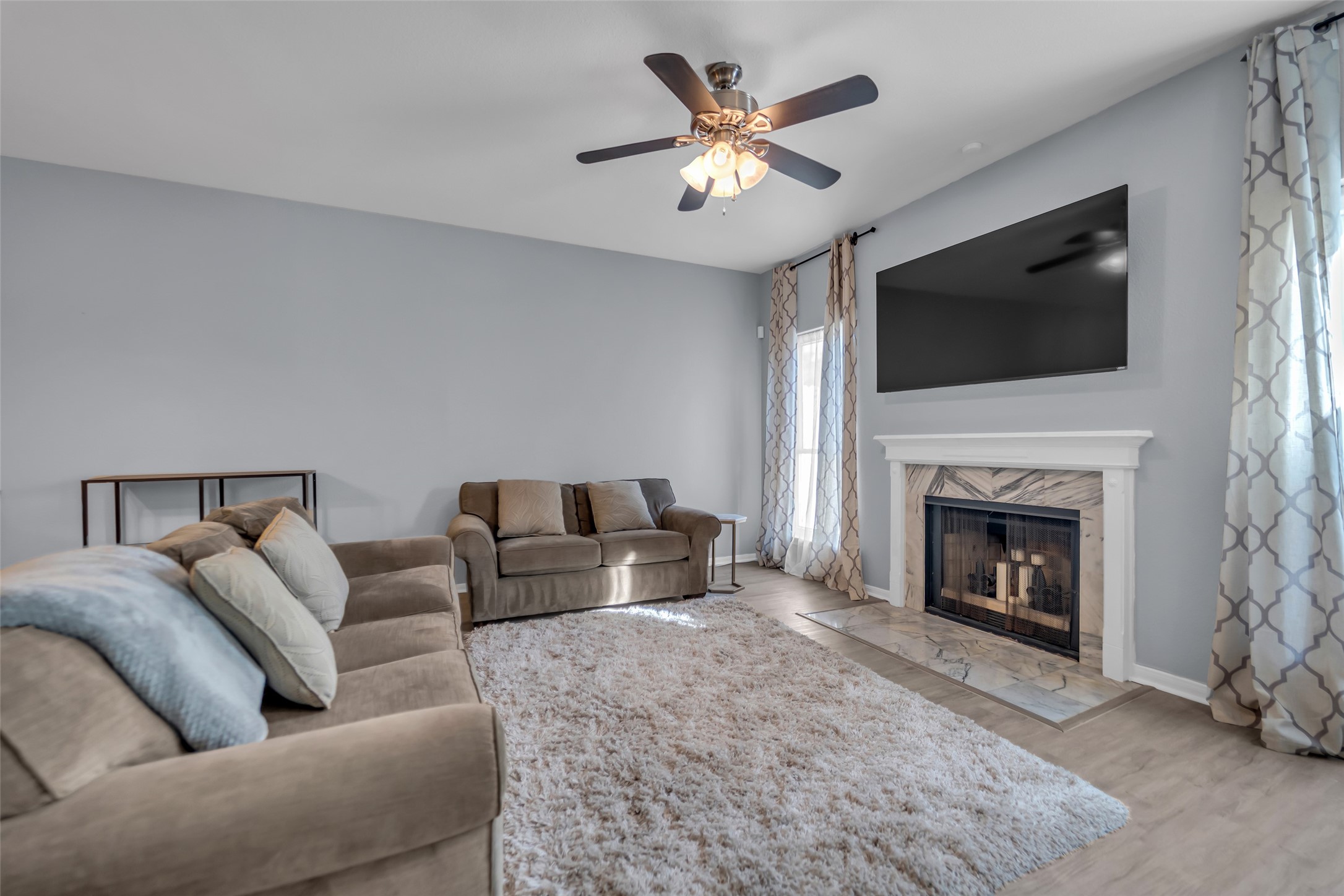 a living room with furniture a fireplace and a flat screen tv