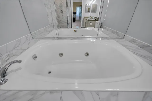 a bathroom with a tub sink and mirror