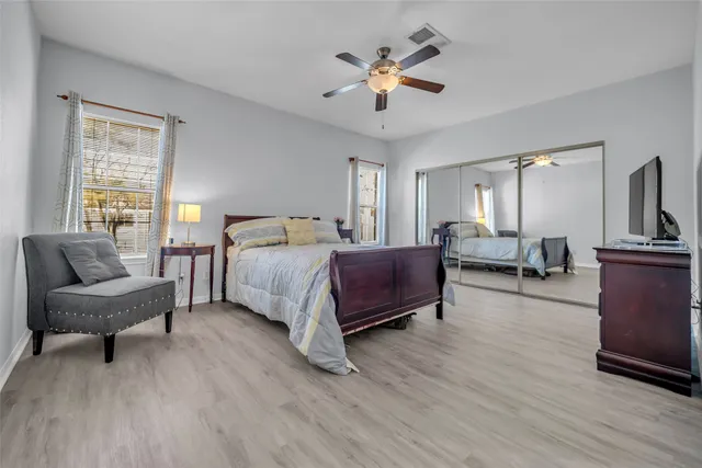 a spacious bedroom with a bed a couch and a chandelier