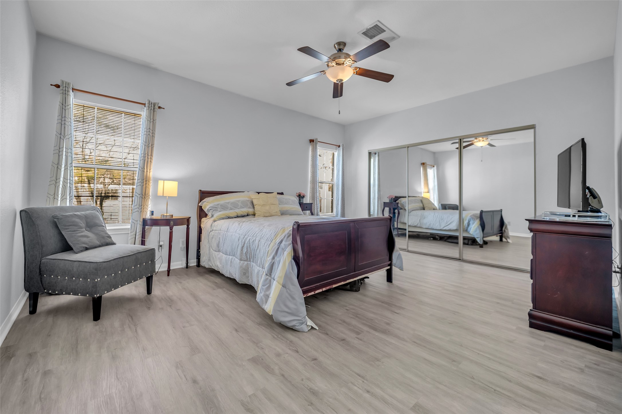 8091 El Mundo Street, Unit 8091 Houston, TX 77054 - Photo 16 of 22 a spacious bedroom with a bed a couch and a chandelier