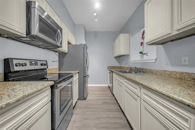 a kitchen with stainless steel appliances granite countertop a stove and a sink