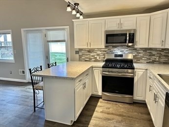 a kitchen with stainless steel appliances a stove a sink and a microwave