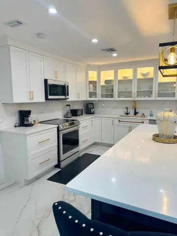 a kitchen with stainless steel appliances a stove a sink a microwave and cabinets
