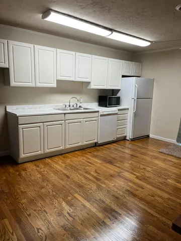 a kitchen with granite countertop a sink and white cabinets