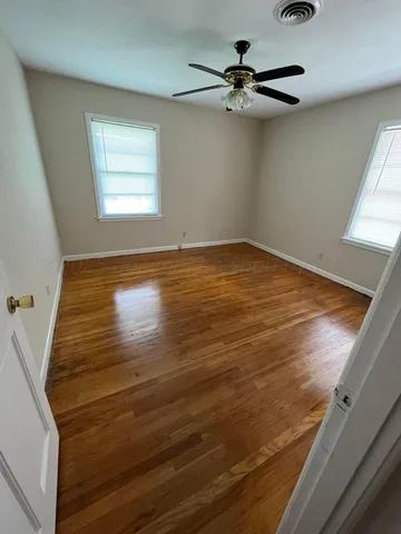 a view of a room with wooden floor and fan