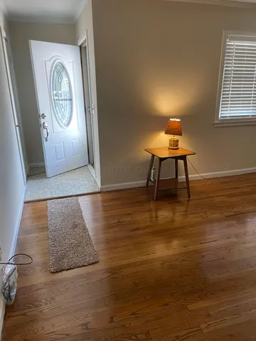 a view of a room with wooden floor table and a chair