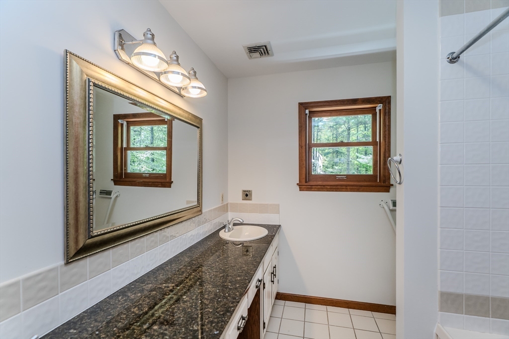 63 Larkspur Drive Amherst, MA 01002 - Photo 31 of 42 a bathroom with a granite countertop sink and a mirror