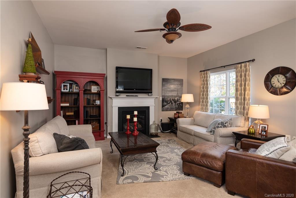 7838 East Berkeley Road Denver, NC 28037 - Photo 7 of 34 a living room with furniture a fireplace and a flat screen tv