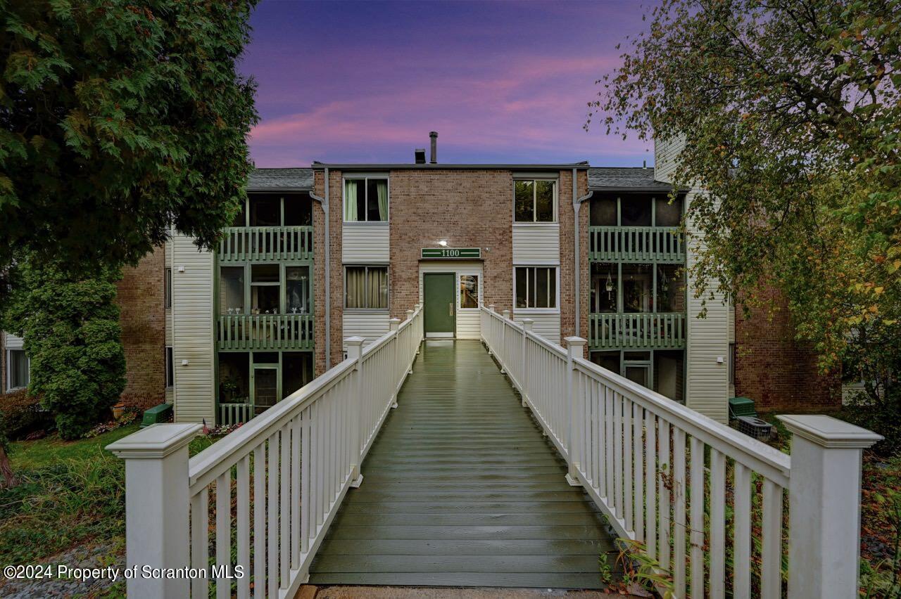 a view of a house with a deck and a yard
