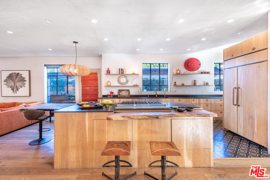 910 Dickson Street Marina del Rey, CA 90292 - Photo 12 of 52 a kitchen with stainless steel appliances granite countertop a table chairs sink and wooden floor