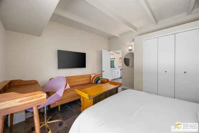 a bedroom with a bed and a flat screen tv