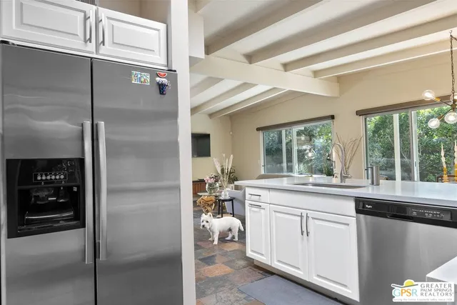 a kitchen with white cabinets and a refrigerator