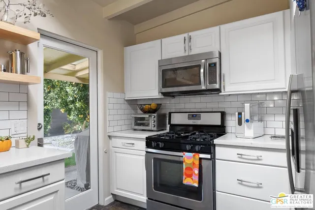 a kitchen with cabinets stainless steel appliances and a sink