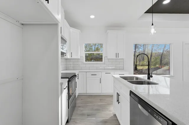 a kitchen with granite countertop a sink and cabinets