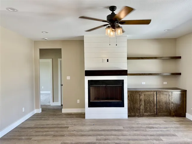 a view of a livingroom with a ceiling fan and hardwood floor
