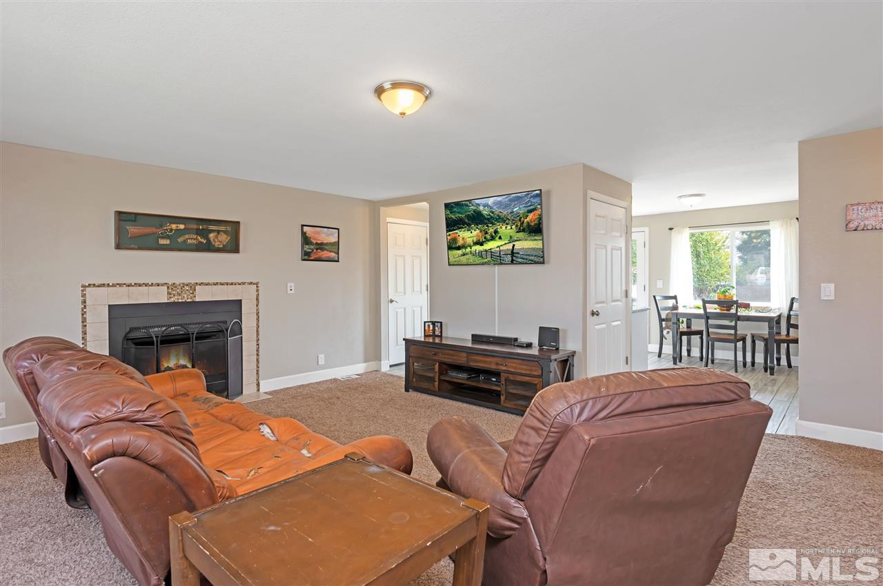 117 Ring Road Dayton, NV 89403 - Photo 8 of 36 a living room with furniture a fireplace and a flat screen tv