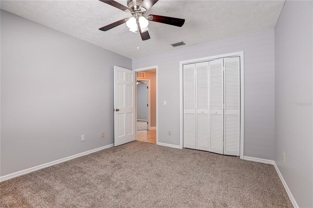 1418 Buckner Road Valrico, FL 33596 - Photo 26 of 37 an empty room with closet and a chandelier fan