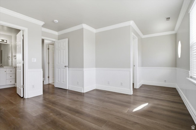 4496 West 11800 South South Jordan, UT 84009 - Photo 15 of 33 Unfurnished bedroom featuring wainscoting, dark wood-style flooring, ornamental molding, and ensuite bathroom