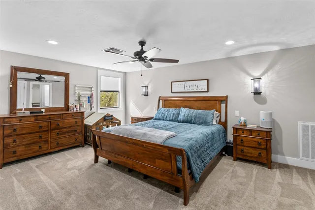 a spacious bedroom with a bed and a dresser in it