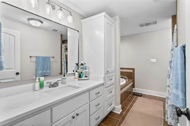 a spacious bathroom with double vanity a mirror and a shower