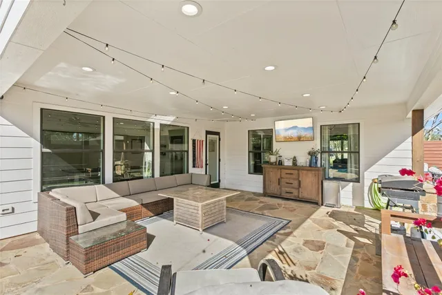 a living room with furniture and large windows