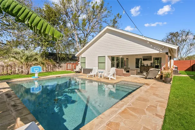 a view of a house with swimming pool and sitting area