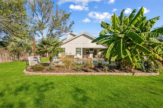 a front view of a house with a garden and trees