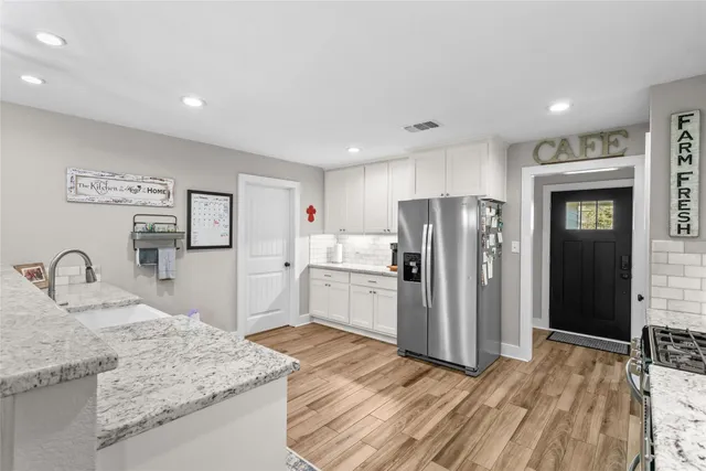 a kitchen with granite countertop a refrigerator and a sink