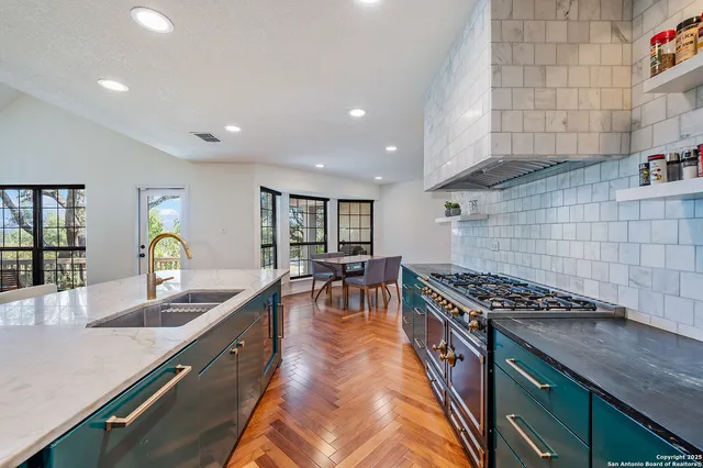 a kitchen with granite countertop a sink a stove and cabinets